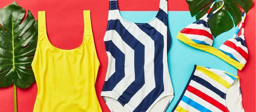 Blue, yellow, red, and black ladies' swimsuits hung on the wall of a store